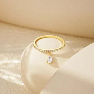 Detailed view of S925 silver ring with small zircons and a teardrop pendant