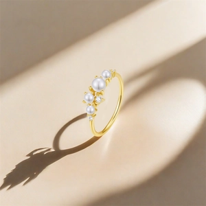 Detailed shot of S925 sterling silver stamp on golden ring with pearls and zircons
