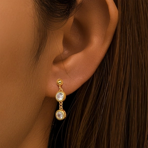 Close-up of S925 sterling silver gold earrings with round zircon stones on model ear