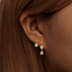 Close-up of S925 sterling silver asymmetrical earrings with zircon on woman's ear