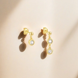Macro detail of S925 sterling silver gold asymmetrical earrings with zircon gemstones