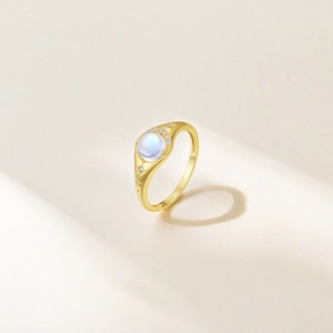 Macro detail of gold S925 ring with blue moonstone and engraved celestial motifs