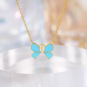 Macro-opname van blauwe vlinder hanger met zirkonia en gouden ketting op standaard