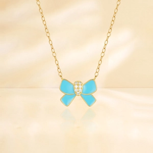Detail van een gouden vlinderketting met lichtblauw emaille en sprankelende diamant