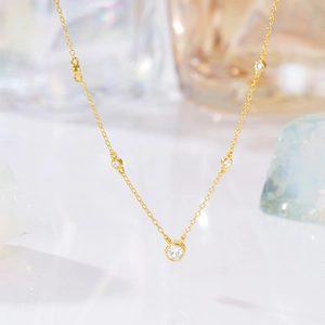 Detailed shot of gold plated necklace featuring five bezel-set round cubic zirconia stones