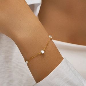 Close-up of elegant gold S925 sterling silver bracelet featuring three sparkling zircons