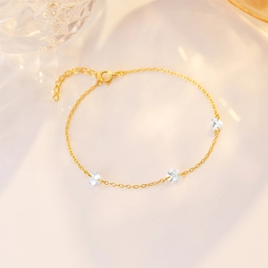 Detail of delicate gold S925 sterling silver chain bracelet with three round cubic zirconias