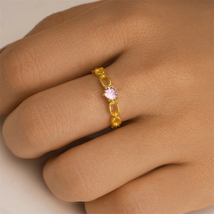Detailed view of a gold chain ring featuring a six-prong set pink round zircon stone