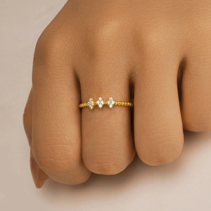 Detail of a golden sterling silver ring with three diamond shapes on a beaded band