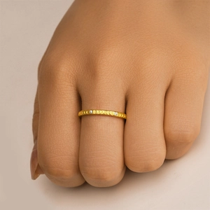 Nahaufnahme vom goldenen Mondphasenring mit gebürsteter Textur und kleinen Diamanten