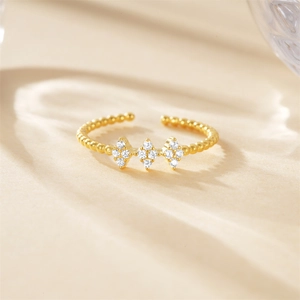 Detail of adjustable gold ring with beaded texture and sparkling white zircon stones
