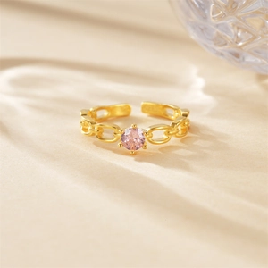 Macro detail of gold chain ring featuring a pink zircon center stone in 4-prong setting