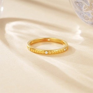 Makro-Detail des goldenen Mondphasen-Rings mit Gravurmustern und kleinen weißen Edelsteinen