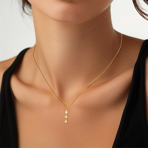 Detail der eleganten goldenen Y-Halskette mit Zirkonia-Tropfen getragen am Hals