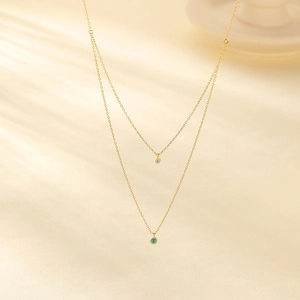 Detail einer doppelten Goldhalskette mit Türkis und funkelnden Diamant-Anhängern