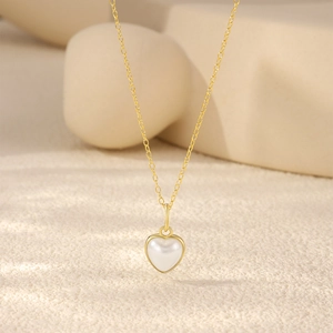 Gros plan d'une chaîne en argent S925 doré avec un pendentif en perle en forme de cœur