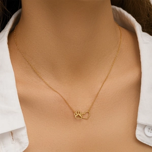 Detail of gold S925 silver necklace with heart and pet paw print pendant on neck