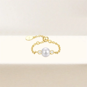 Dettaglio dell'anello regolabile in argento S925 dorato con perla bianca e piccoli diamanti