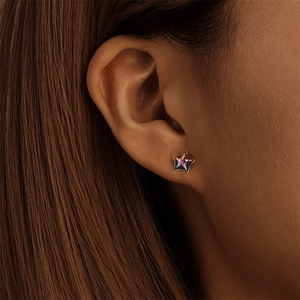 Clou d'oreille en forme d'étoile avec fini métallisé irisé porté sur l'oreille