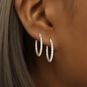 Close-up of S925 sterling silver hoop earrings with sparkling diamond-cut texture details