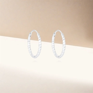 Close-up of S925 sterling silver hoop earrings with textured diamond-cut finish