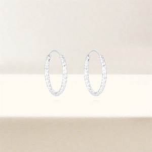 Detailed view of S925 sterling silver hoop earrings with diamond-cut diamond pattern texture