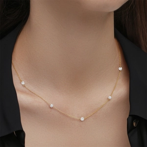 Primer plano de un collar de plata s925 dorada con perlas blancas y circonitas brillantes