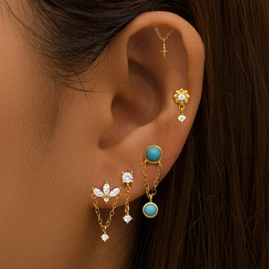 Detail van gouden oorknoppen set met turquoise ketting en marquise zirkonia stenen