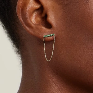 Detailed macro view of S925 silver gold-plated earring with five green gemstones and chain