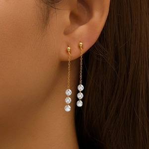 Detailed view of long gold tassel earrings with shimmering crystals on elegant model
