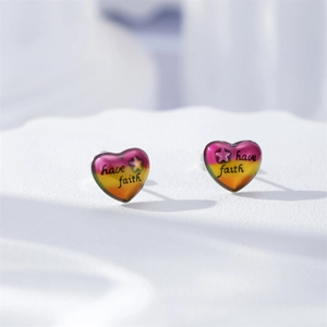Détail de boucles d'oreilles cœur avec dégradé multicolore et gravure have faith