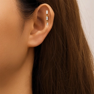 Detail van S925 zilveren oorpiercing met drie verticale baguette-zirkonia's op een model