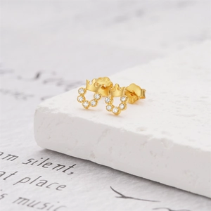 Makroaufnahme eines vergoldeten S925 Silber Kronenohrrings mit weißen Zirkoniasteinen