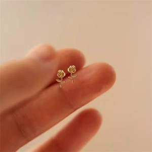 Detailansicht der mini goldenen Rosen-Ohrstecker mit feinen Blütenblättern und Blättern