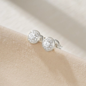 Détails macro de boucles d'oreilles halo en argent S925 avec pierre centrale ronde