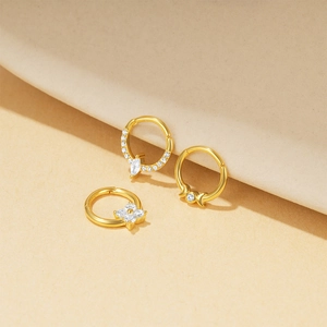 Detail of three gold s925 silver piercing rings with opal and marquise zircon accents