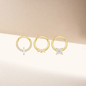 Detailed view of three gold S925 silver piercing hoops with opal and marquise zircon accents