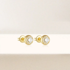 Gros plan détaillé de boucles d'oreilles halo dorées avec pierres rondes claires