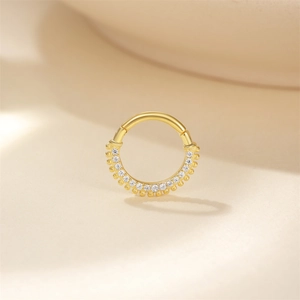 Dettaglio anello in argento dorato con micro-pavé di zirconi e bordo perlato