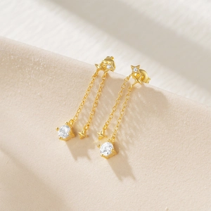 Macro shot of silver tassel earrings with star charms and sparkling zircon stones