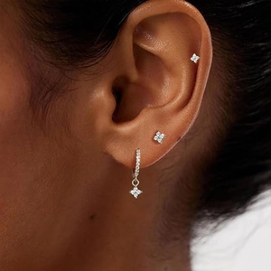 Macro view of S925 silver four-petal flower earrings set with sparkling zircon stones