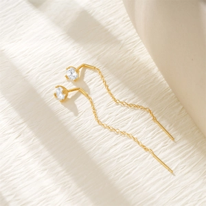 Macro shot of S925 sterling silver stamp on golden tassel earrings with sparkling zircon