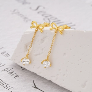 Detail of s925 silver bow tassel earrings with zircon pendant on elegant stone decor