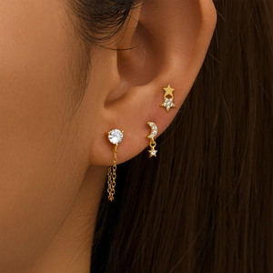 Macro shot of gold S925 silver star and moon stud earring set with sparkling zircons