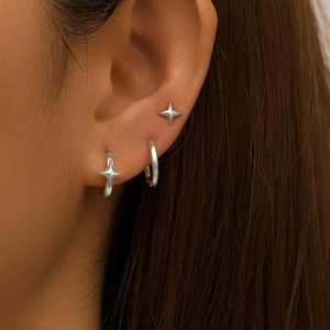 Detailed view of S925 sterling silver star stud and hoop earrings set on female ear