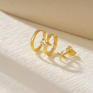 Macro shot of gold S925 sterling silver star earrings with visible hallmark stamps