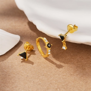 Detailed view of gold S925 sterling silver star moon earrings set with black and white stones