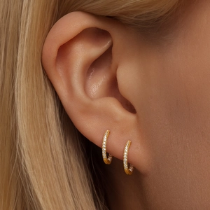 Close-up of gold plated silver wave hoop earrings with micro-pave crystals on ear