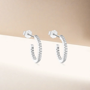 Macro shot of S925 sterling silver stamp and zircon stones on C-shape hoop earrings