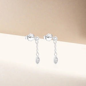 Dettaglio di orecchini S925 in argento a nappa con zirconi brillanti e pendente cuore